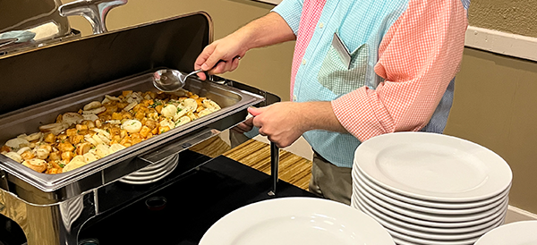 A kitchen server help mix up warm vegetables for an event at the Paducah Convention Center. 